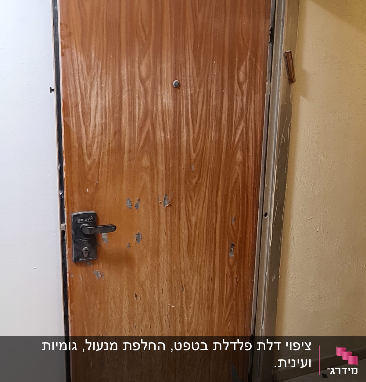 דלת עץ עם שריטות ופגמים, ידית מתכת שחורה